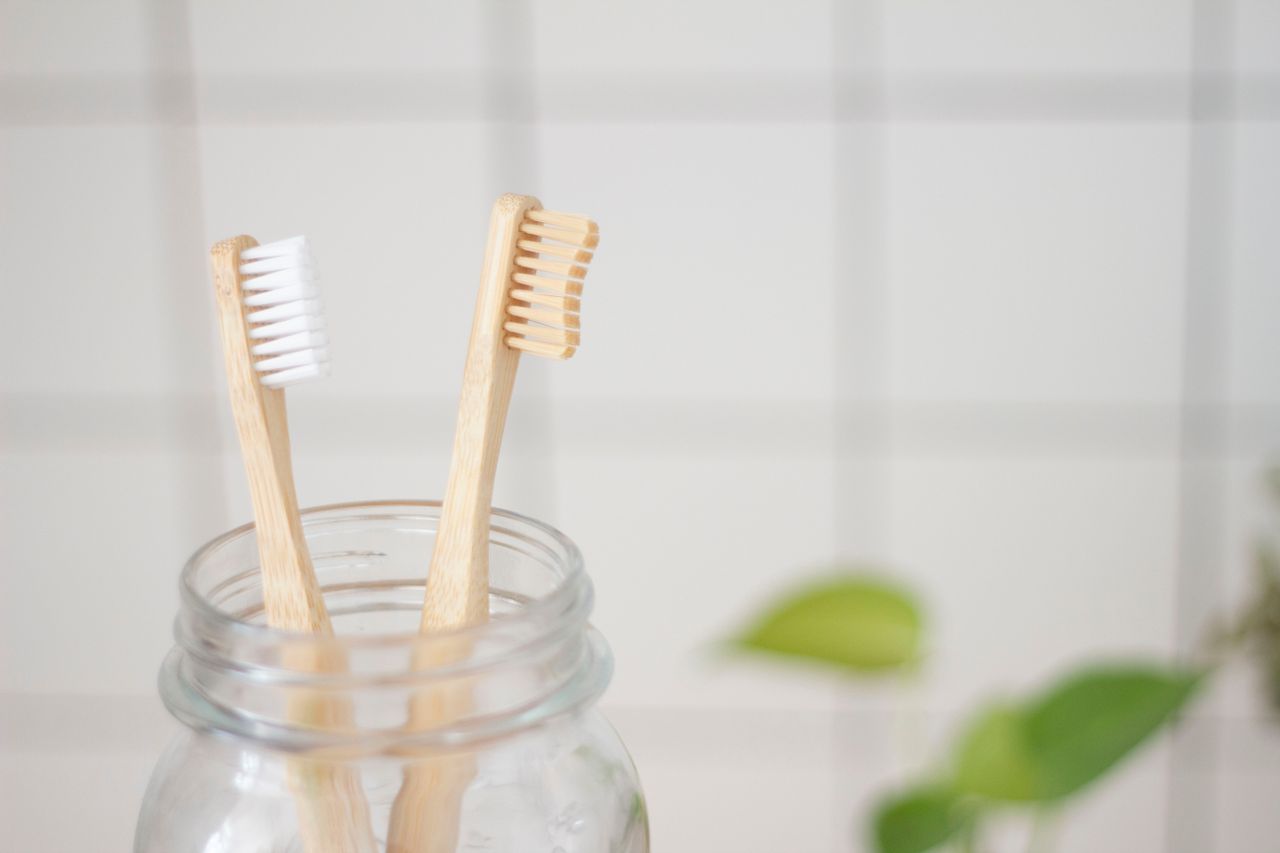 Close-up of bamboo toothbrushes in a glass jar. Perfect for eco-conscious hygiene products.